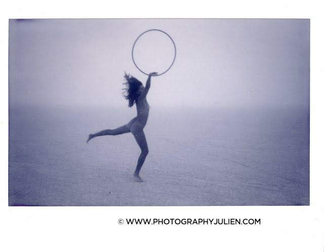 Black and white photo of Gemma hoop dancing in the desert fog, hair mid-toss, photo by www.photographyjulien.com